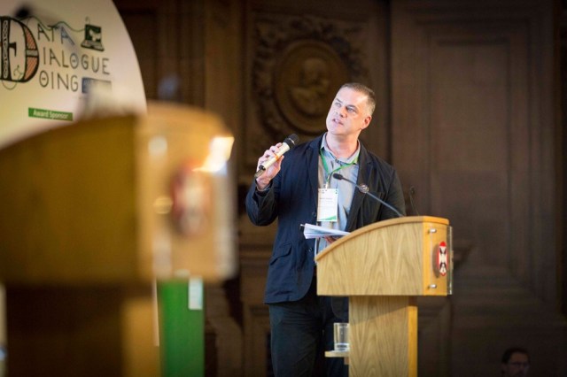 Presenting at the ALT Conference 2019. Standing on stage at lectern.